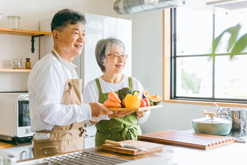 野菜を持つ日本人の高齢者夫婦（シニア老夫婦）
