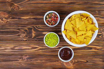 Mexican nachos with cheese. Corn chips with guacamole, salsa and tomato ketchup.