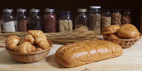 Fresh Baked Bread in Rustic Kitchen on Wooden Table With Jars of Dried Food in Background Shallow DOF