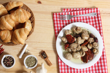 Mushrooms, Sun Dried Tomato, Olives and Capers in Olive Oil on rustic table