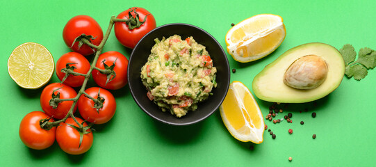 Composition with tasty guacamole and ingredients on green background