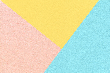 Texture of craft pink, blue and light yellow shade color paper background, macro. Vintage abstract pastel cardboard