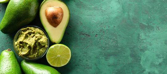 Bowl with delicious guacamole, lime and ripe avocados on green background with space for text - obrazy, fototapety, plakaty
