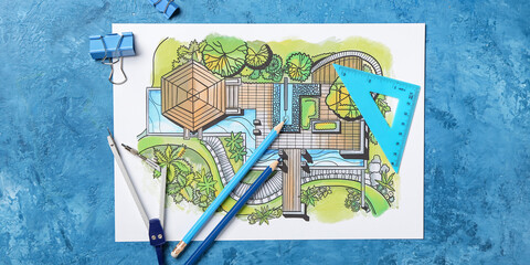 Landscape designer's plan with stationery on blue background, top view