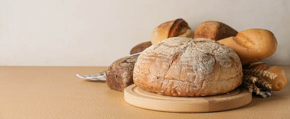 Different fresh bread on light background with space for text