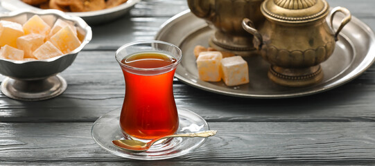 Glass cup of hot Turkish tea on wooden table