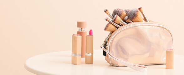Set of makeup brushes with decorative cosmetics on table