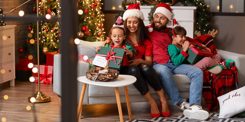 Happy family with gifts celebrating Christmas at home