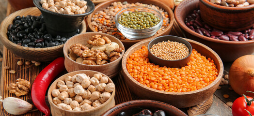 Different raw legumes with nuts on table