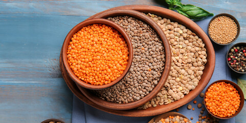 Different raw lentils on blue wooden background