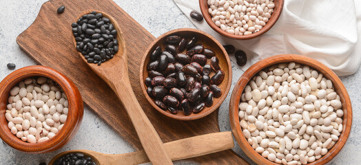 Different types of beans on light background, top view