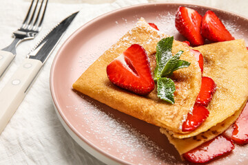 Plate of thin pancakes with strawberries and sugar powder on white background, closeup