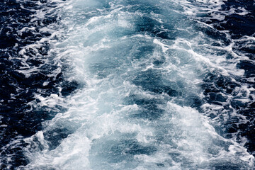 Fototapeta na wymiar Waves and foam in the sea from boat engine