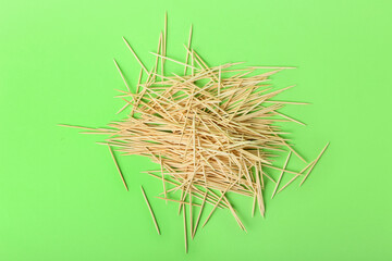 Obraz premium Heap of wooden toothpicks on green background