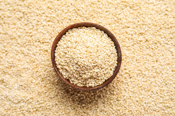 Wooden bowl with sesame seeds as background
