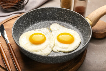 Frying pan with tasty eggs on table, closeup