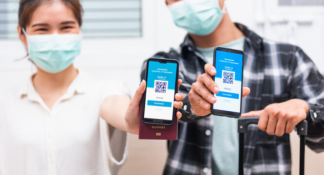Asian young couple woman and man ready to travel showing digital vaccine health passport certificate app in smartphone screen during coronavirus pandemic, Mobile app of virus covid-19 vaccination
