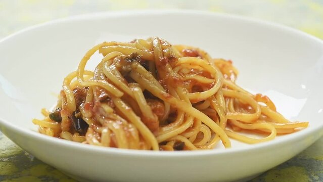 The chef serves pasta alla norma.
