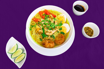 INDONESIAN CULINARY CHICKEN SOUP NOODLE WITH SLICE BOILING EGG AND FRIED MASHED POTATOS AS TOPPING
