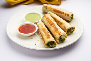 Indian paneer bread roll made using spiced grated cottage cheese mixed with spices & rolled & baked