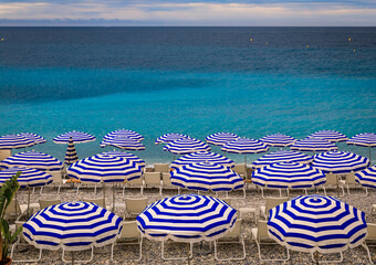 Pebble beach with beach umbrellas and chairs on Mediterranean Sea in Nice France © SvetlanaSF