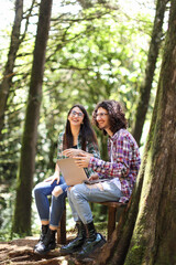 Young latin couple sitting in the forest smiling and woman with expression at Costa Rica