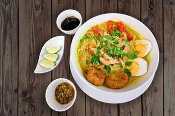 INDONESIAN CULINARY CHICKEN SOUP NOODLE WITH SLICE BOILING EGG AND FRIED MASHED POTATOS AS TOPPING
