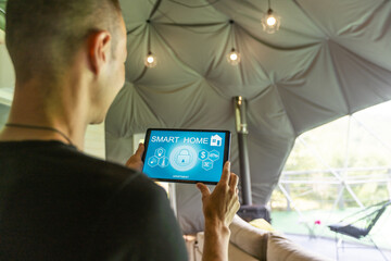 Smart home control on tablet. Interior of living room in the background