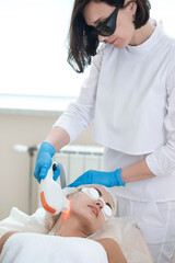 Skin Procedures. Female Woman Receiving Facial Beauty Treatment While Removing Pigmentation in Clinic During Pulsed Laser Light Therapy or IPL Rejuvenation.