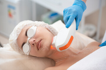 Beauty Cosmetology Concepts. Beautician Using Laser Therapy For Facial Skin Rejuvenation for Body...