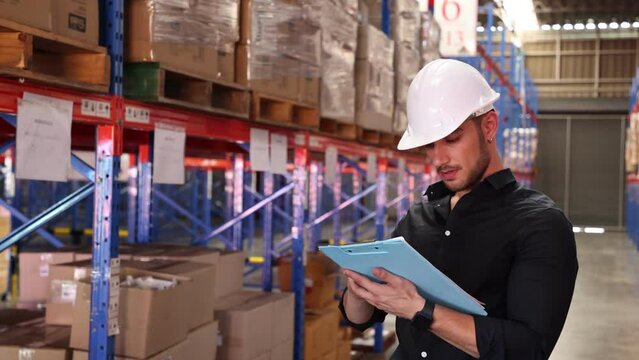 Professional Man Worker wearing hard hat checks stock and inventory with Clipboard in the retail of shelves with goods.