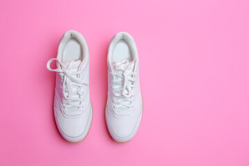 Upper View of Pair of New White Sneakers Over Pink Seamless Background.