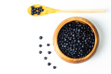 Organic Food Ideas. Heap of Forest Fresh Blueberries in Wooden Bowl With Spoon Over White Background