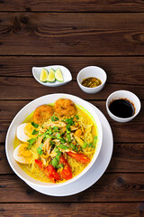 INDONESIAN CULINARY CHICKEN SOUP NOODLE WITH SLICE BOILING EGG AND FRIED MASHED POTATOS AS TOPPING