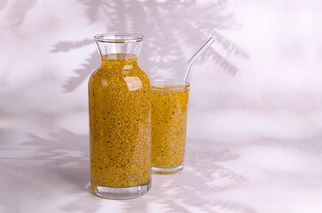 Yellow drink with seeds in a glass