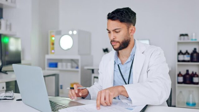 Confused, annoyed and serious scientist thinking about medical research problem while working in a lab. Young chemical engineer analyzing data, doing hard work but finding it difficult to find a fix