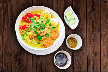INDONESIAN CULINARY CHICKEN SOUP NOODLE WITH SLICE BOILING EGG AND FRIED MASHED POTATOS AS TOPPING