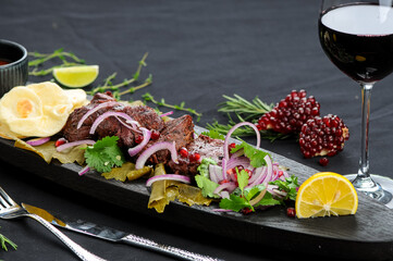 fried shish kebab in a plate on grape leaves
