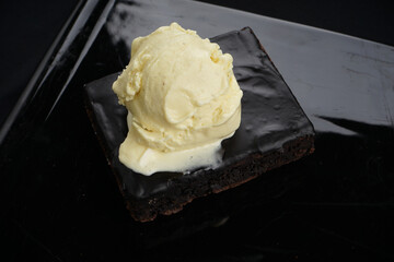 dessert chocolate cake on a black plate with ice cream macro photo
