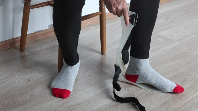 Ankle-foot orthosis, foot drop support brace is attached to injured leg.