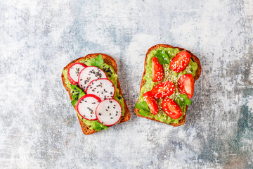 Avocado toasts with cherry tomatoes and raddish slices,sesame seeds.