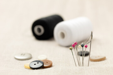 Spool of thread and needles for sewing, close-up