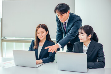 オフィスで会議をするスーツ姿の男女
