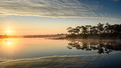 view of the sunrise over the lake in the national park. Beautiful rainforest landscape with mist in the morning.
