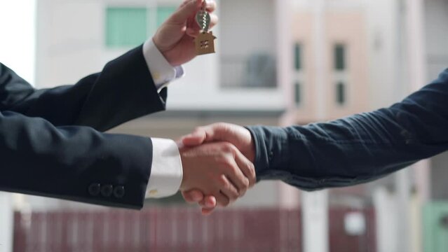 Real estate agent shakes hands with customer. The house is sold successfully after the customer agrees to sign a house building contract. Mortgage, rent, buy, sell, purchase,move,Selling home.