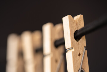 Den Helder, Netherlands. July 2022. Wooden clothes pegs on a black background. Selective focus.