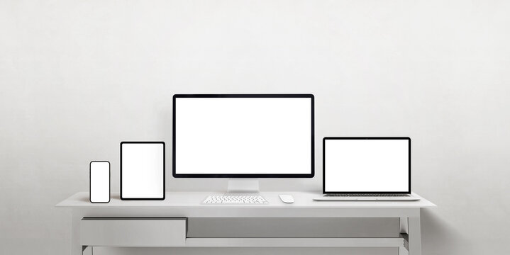 Isolated displays different sizes to promote responsive web pages or apps. Computer display, laptop, tablet and smart phone on work desk