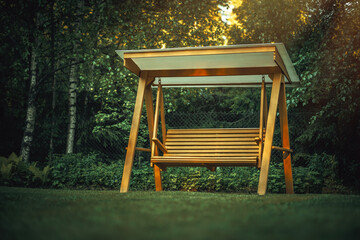 Wooden swing for relaxing in the garden.Garden furniture with your own hands. Landscape design in...