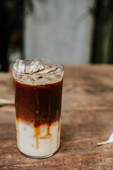 Iced caramel macchiato coffee on wooden table.
