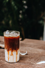 Iced caramel macchiato coffee on wooden table.
